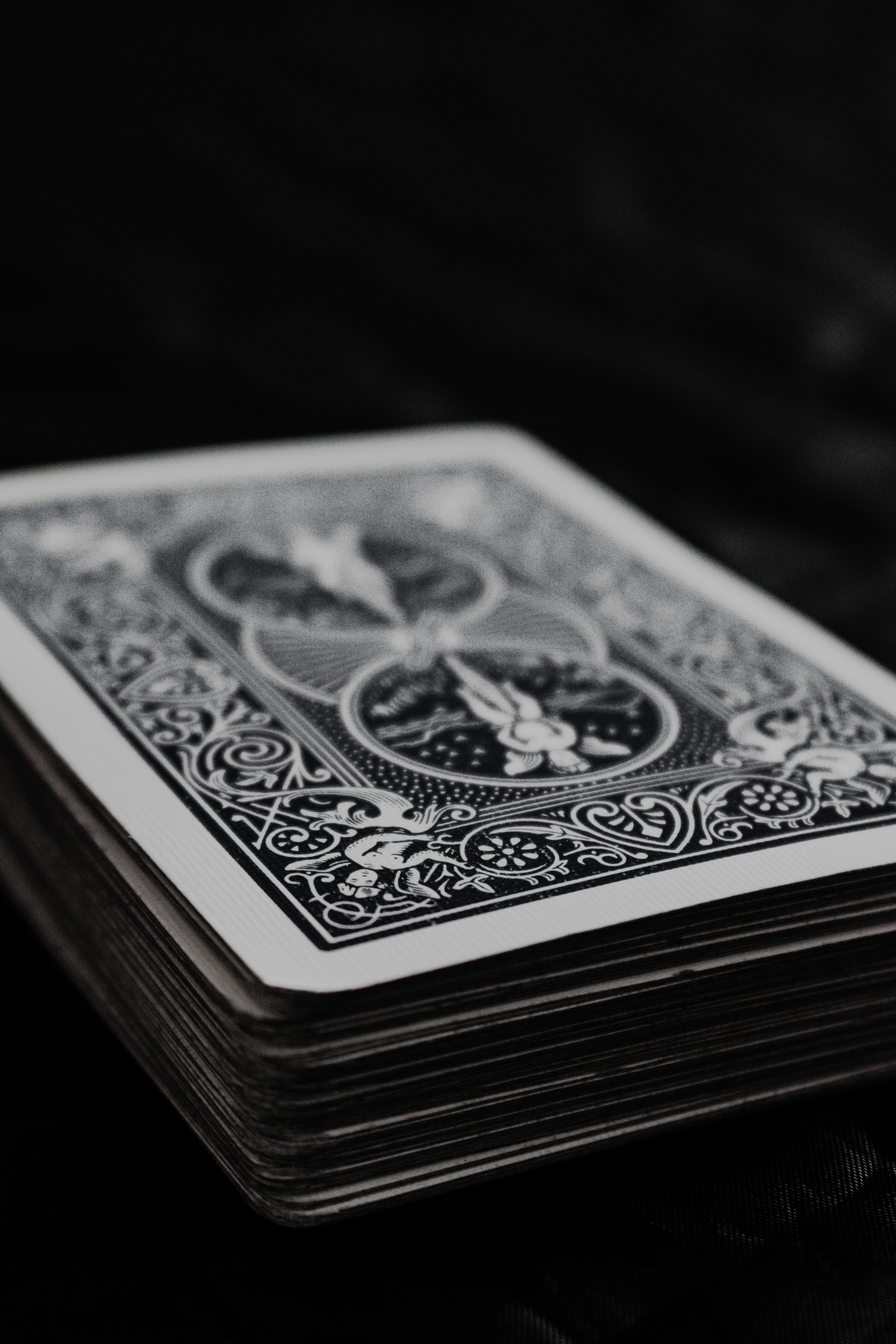 black and white photo of a deck of playing cards against a black background